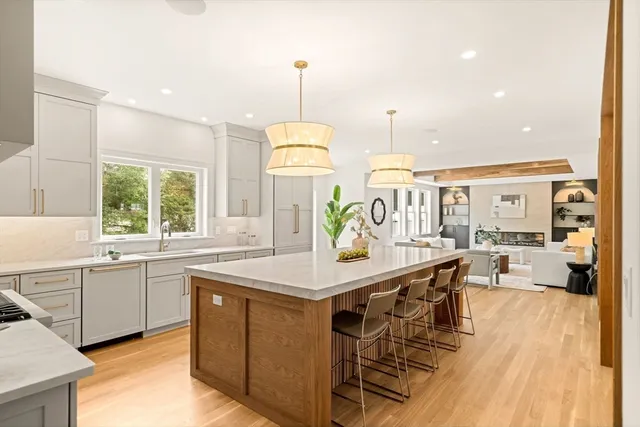 a kitchen with a table chairs sink and wooden floor