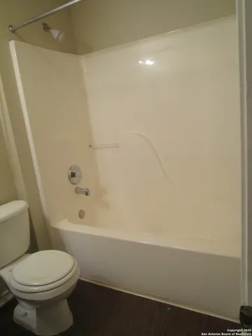 a bathroom with a toilet and a bath tub