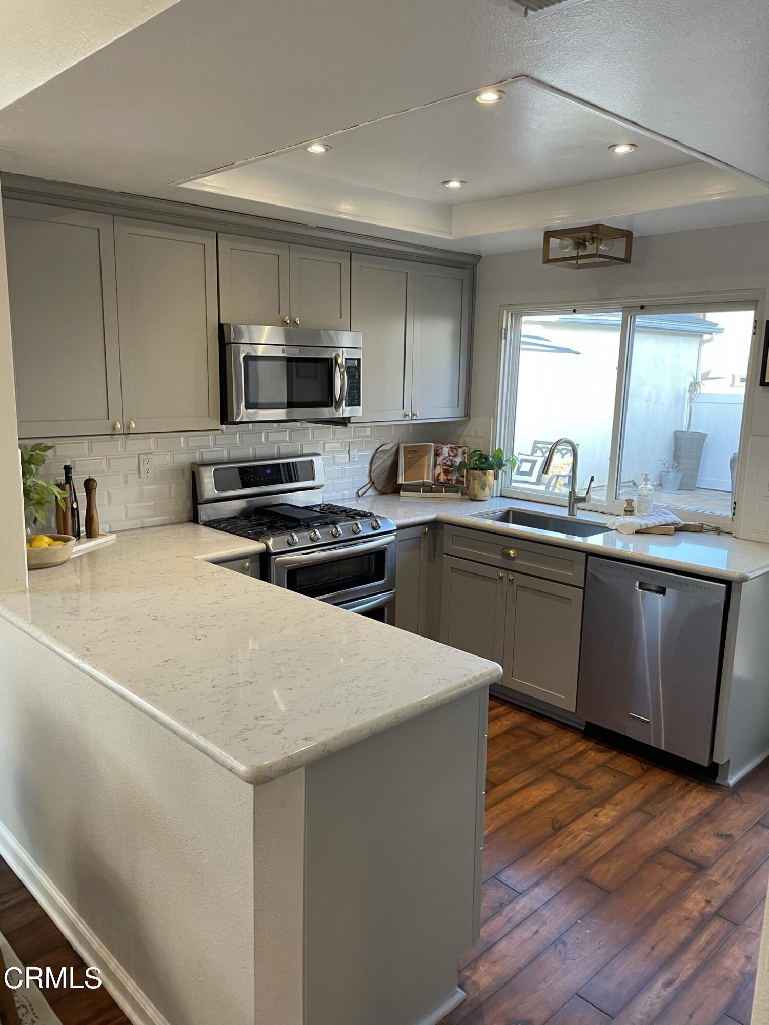 7 Racing Wind Irvine, CA 92614 - Photo 11 of 31 a kitchen with stainless steel appliances a sink a stove a microwave a center island and a window