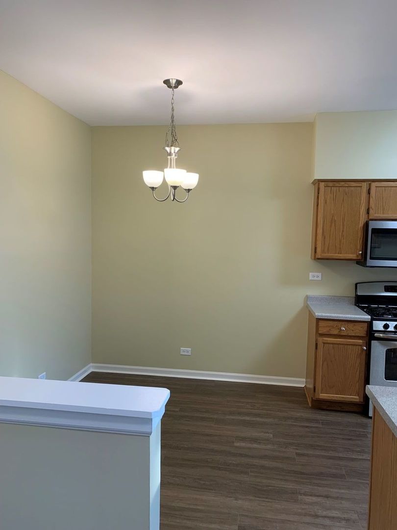 17783 Braewick Road Gurnee, IL 60031 - Photo 7 of 18 a room with stainless steel appliances wooden floor a fireplace and a window