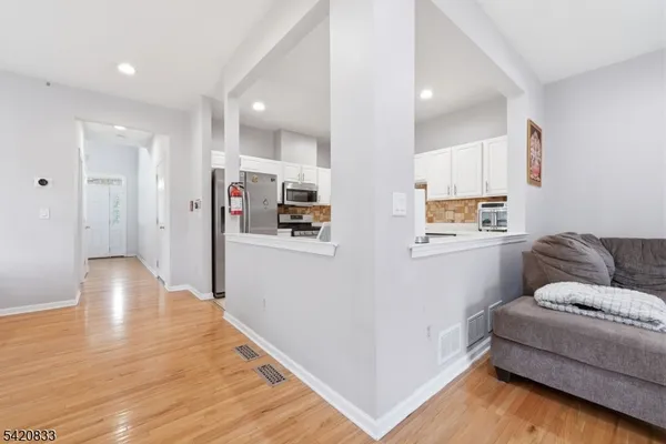 a kitchen with granite countertop white cabinets and stainless steel appliances