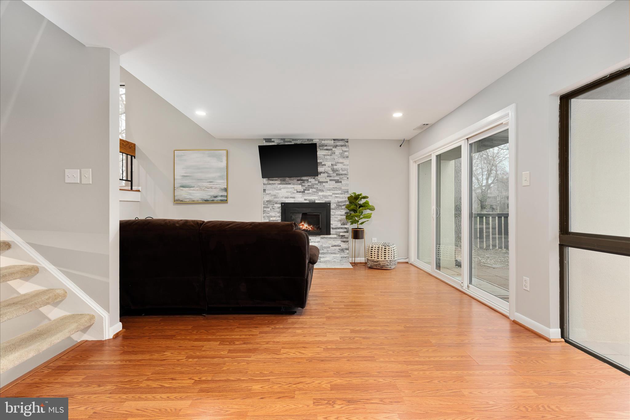 11608 Newbridge Court Reston, VA 20191 - Photo 11 of 47 a living room with furniture a flat screen tv and a fireplace