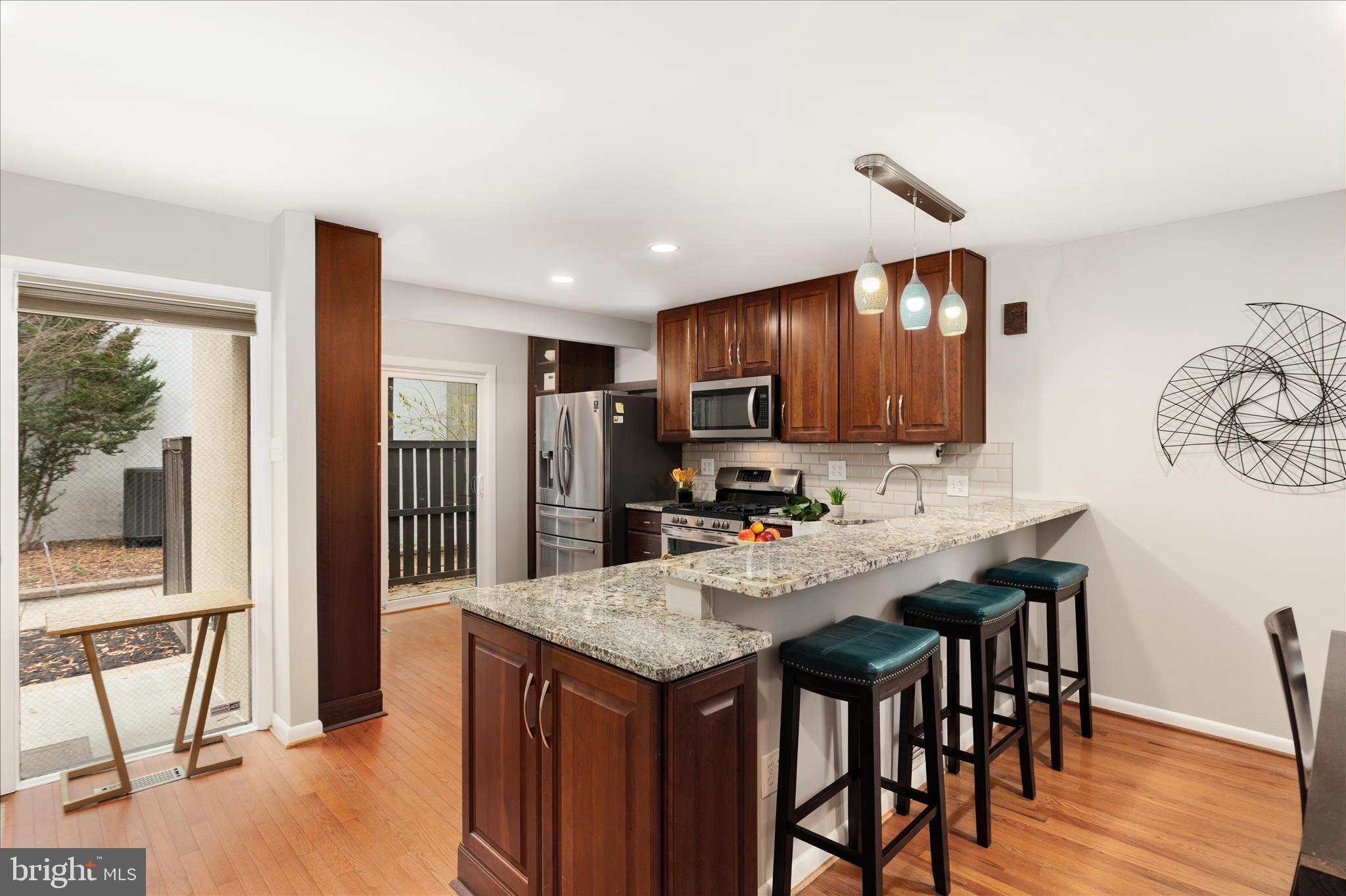 11608 Newbridge Court Reston, VA 20191 - Photo 4 of 47 a kitchen with stainless steel appliances granite countertop a table chairs refrigerator and sink
