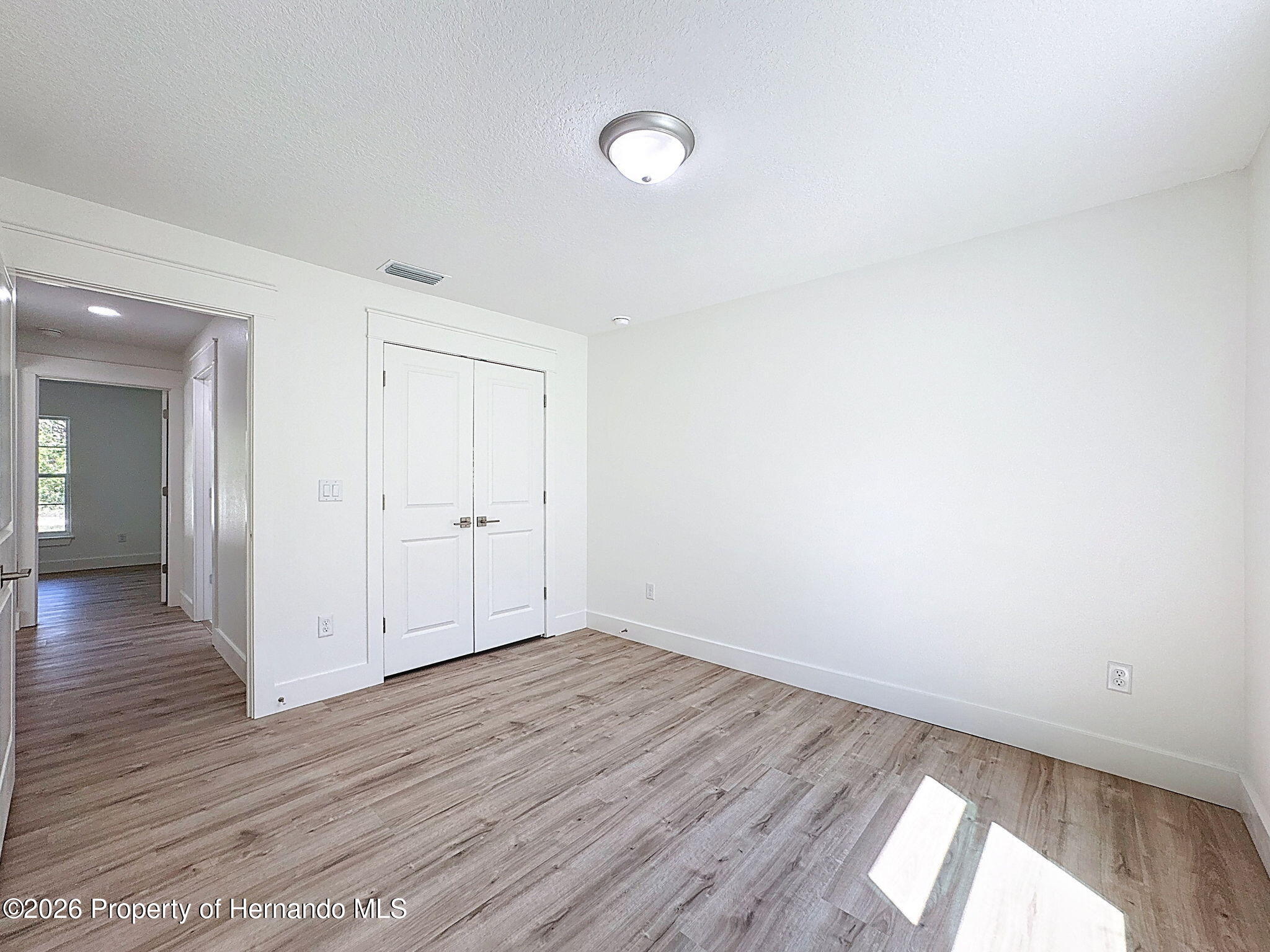 8988 Waterbird Way Weeki Wachee, FL 34613 - Photo 39 of 42 a view of an empty room with wooden floor and a window