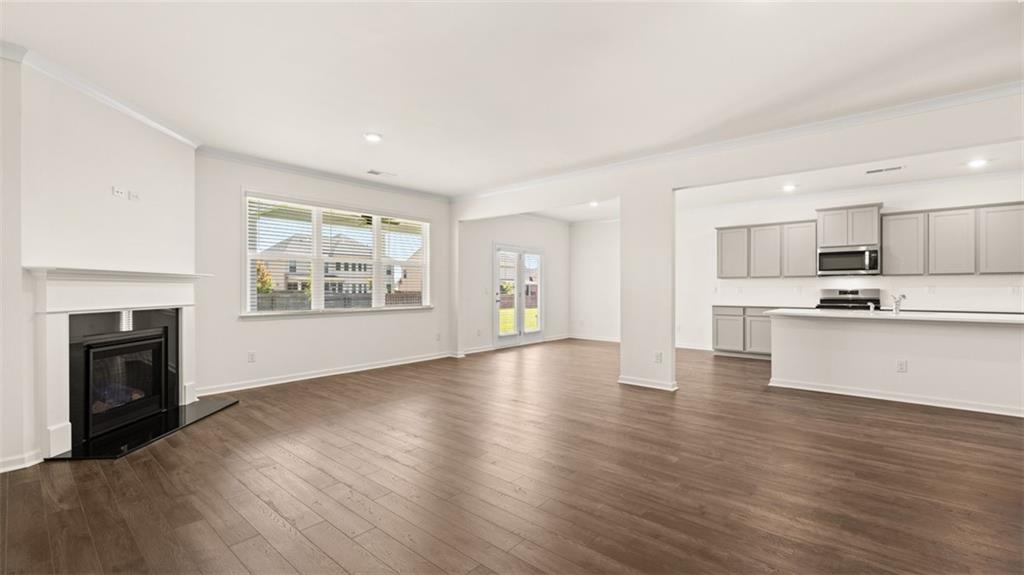 71 Weymouth Drive Locust Grove, GA 30248 - Photo 19 of 56 a view of an empty room with window and wooden floor