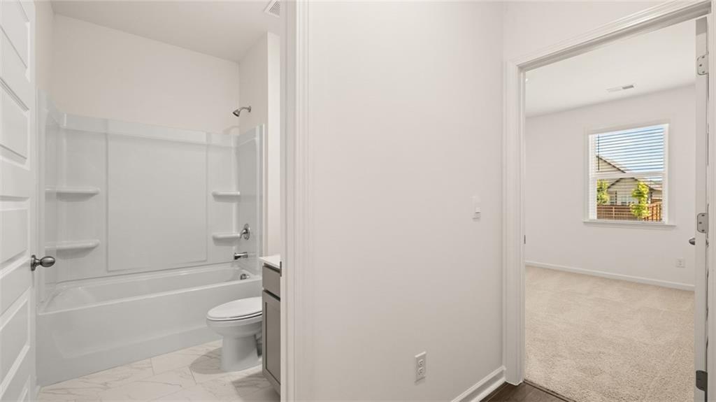 71 Weymouth Drive Locust Grove, GA 30248 - Photo 25 of 56 a bathroom with a granite countertop toilet a sink and bathtub