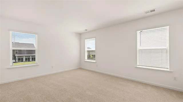 a view of room with bathroom and windows