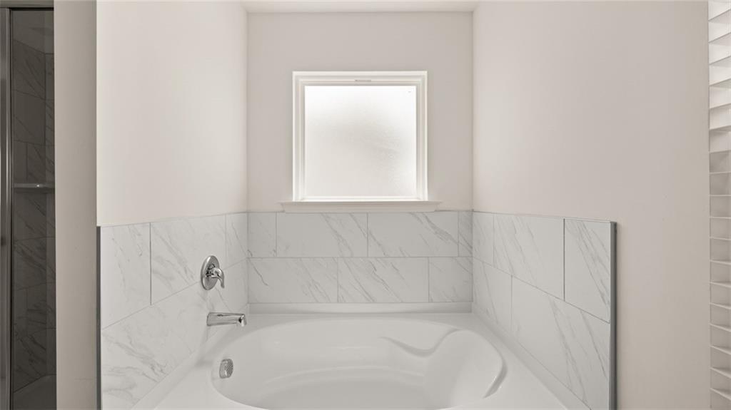 71 Weymouth Drive Locust Grove, GA 30248 - Photo 38 of 56 a white bath tub sitting in a bathroom