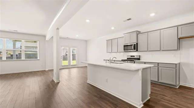 a kitchen with stainless steel appliances granite countertop a sink stove and wooden floor