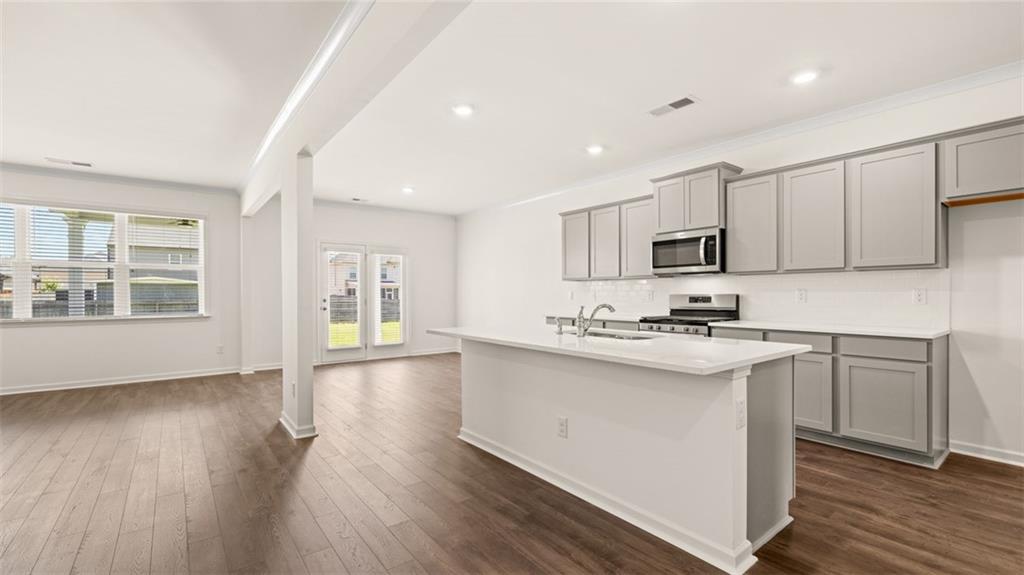 71 Weymouth Drive Locust Grove, GA 30248 - Photo 5 of 56 a kitchen with stainless steel appliances granite countertop a sink stove and wooden floor