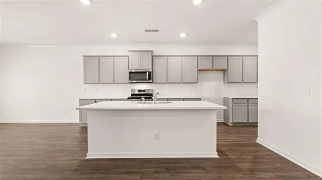 a kitchen with kitchen island white cabinets and refrigerator