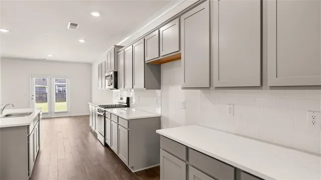 a kitchen with a sink and wooden floor