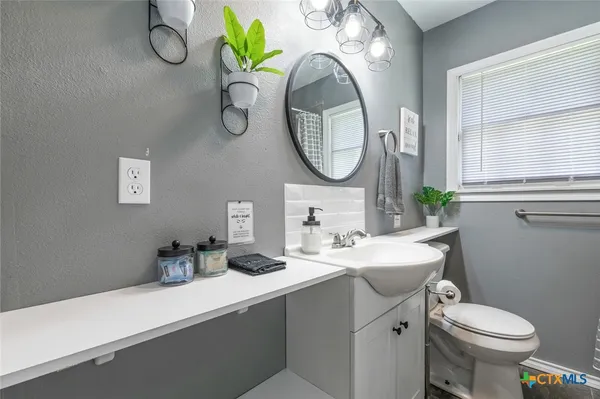 a bathroom with a toilet sink and mirror