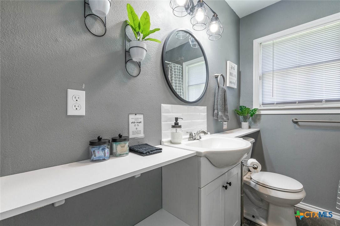 1609 South 39th Street Temple, TX 76504 - Photo 11 of 19 a bathroom with a toilet sink and mirror
