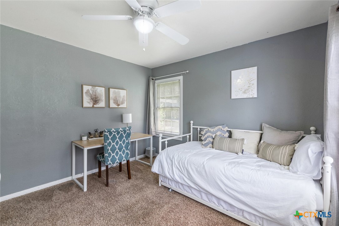 1609 South 39th Street Temple, TX 76504 - Photo 15 of 19 a bedroom with a bed and a chandelier