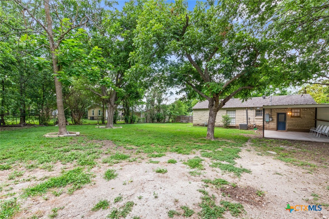 1609 South 39th Street Temple, TX 76504 - Photo 18 of 19 a view of a yard with a house and trees in the background