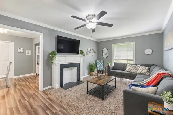 a living room with furniture a fireplace and a flat screen tv