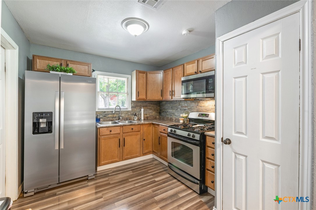1609 South 39th Street Temple, TX 76504 - Photo 8 of 19 a kitchen with stainless steel appliances granite countertop a stove a refrigerator and a refrigerator