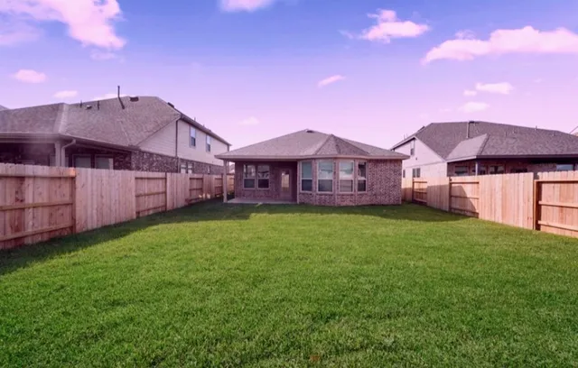a view of a yard in front of a house with a small yard and a large tree