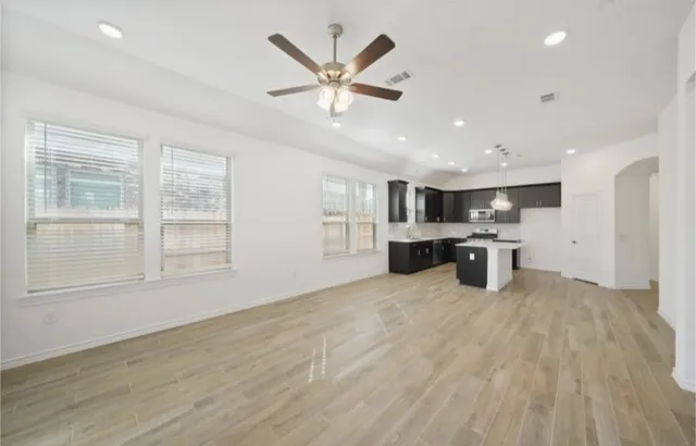 a view of an empty room with a kitchen