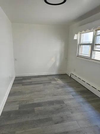 a view of a room with wooden floor and window