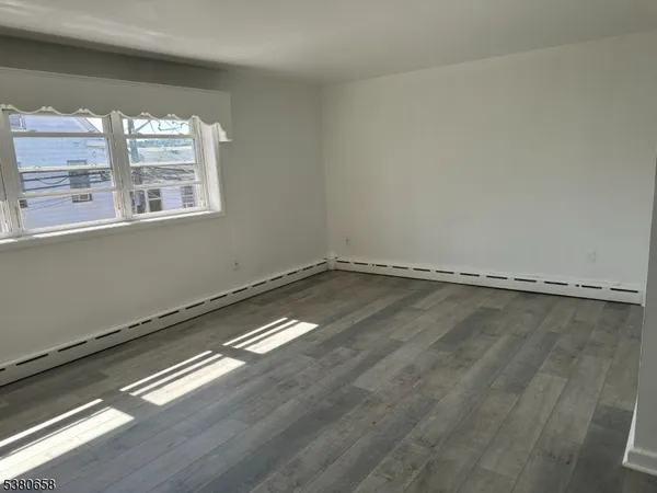 a view of a room with wooden floor and window
