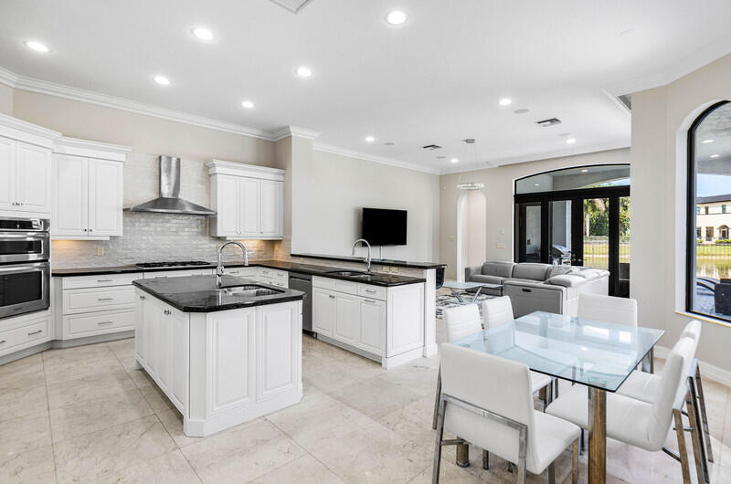 17895 Cadena Drive Boca Raton, FL 33496 - Photo 13 of 49 a kitchen with stainless steel appliances kitchen island granite countertop a sink and stove