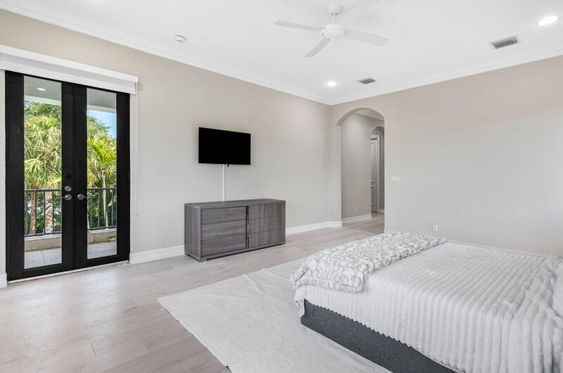 17895 Cadena Drive Boca Raton, FL 33496 - Photo 40 of 49 a spacious bedroom with a large bed and a flat screen tv