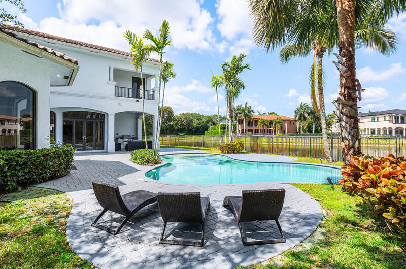 17895 Cadena Drive Boca Raton, FL 33496 - Photo 46 of 49 a view of a patio with couches table and chairs under an umbrella