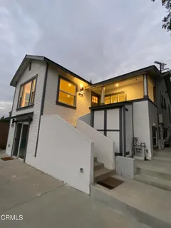 a view of a house with backyard and parking