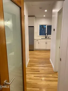 a view of a hallway with wooden floor