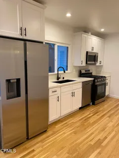 a kitchen with stainless steel appliances granite countertop a stove a sink and a refrigerator