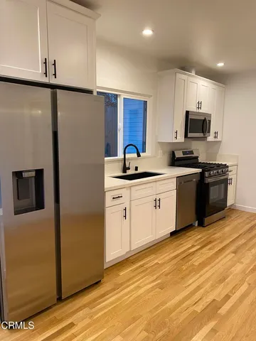 a kitchen with stainless steel appliances granite countertop a stove a sink and a refrigerator