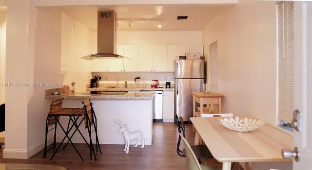 a kitchen with a table chairs refrigerator and cabinets