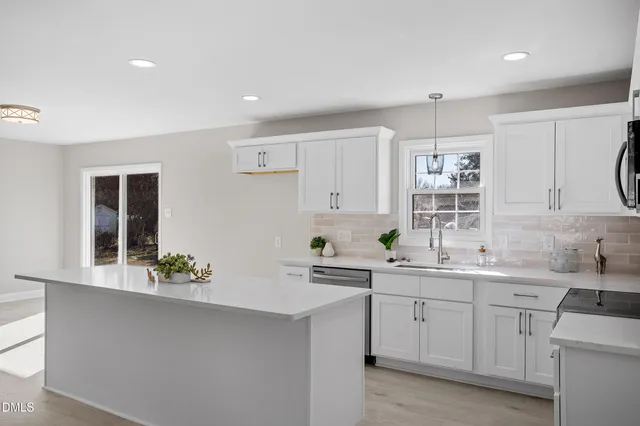 a kitchen with a sink dishwasher stove and cabinets