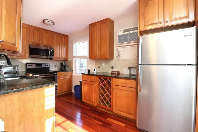 a kitchen with stainless steel appliances granite countertop a refrigerator a stove top oven a sink and dishwasher