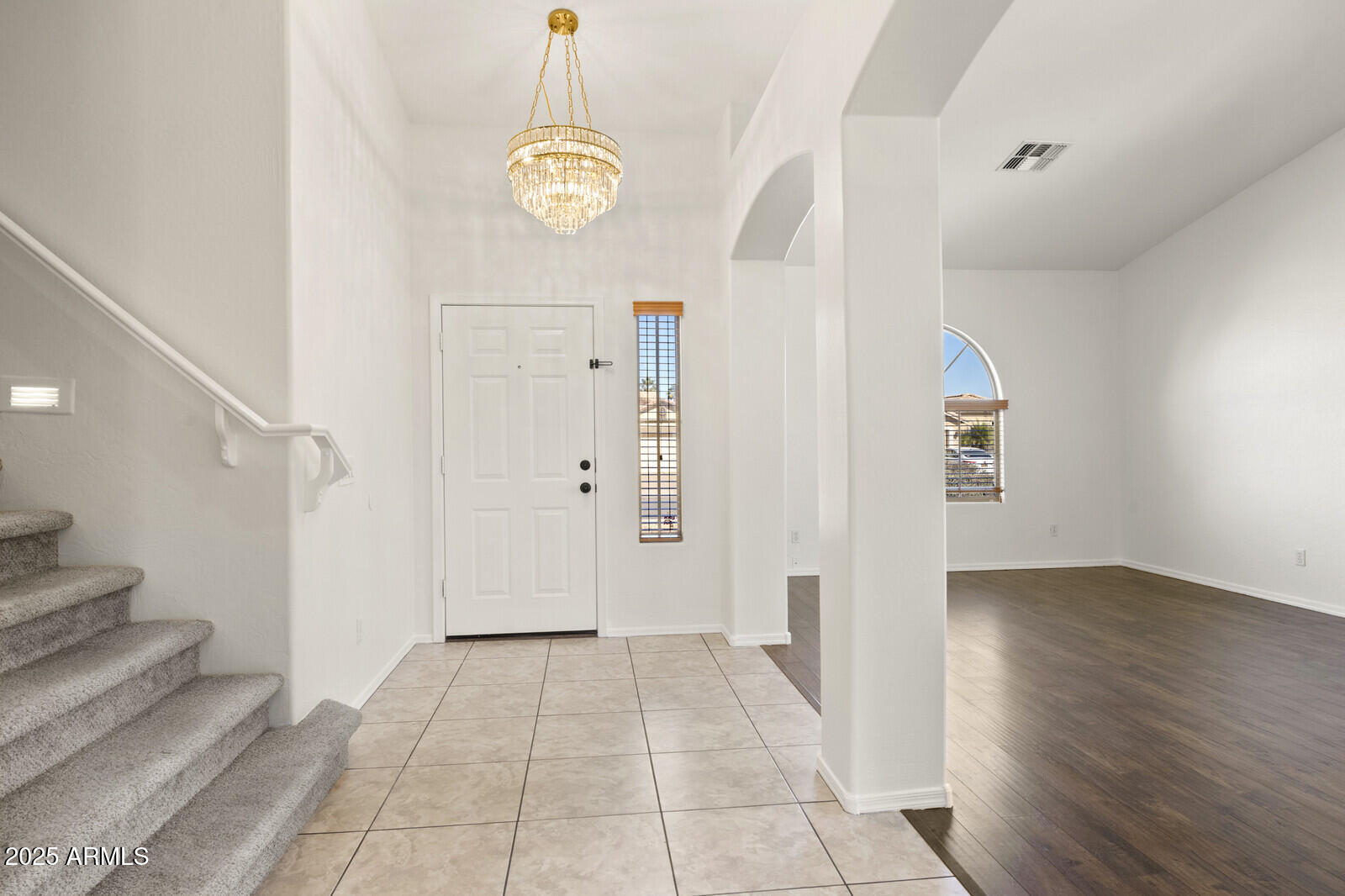 3297 East Warbler Road Gilbert, AZ 85297 - Photo 5 of 32 a view of an empty room with wooden floor and stairs