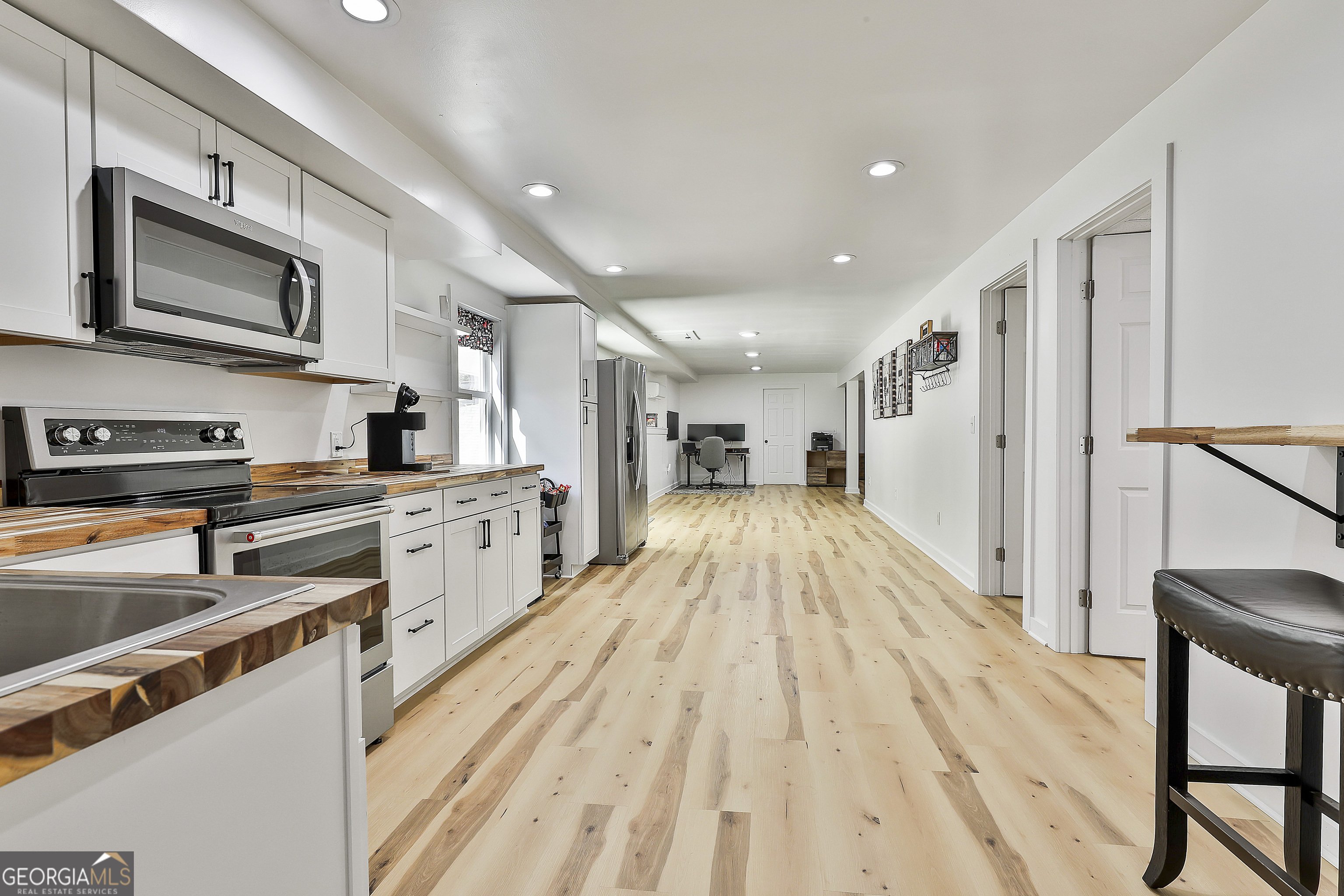 465 Little Road Sharpsburg, GA 30277 - Photo 43 of 67 a open kitchen with stainless steel appliances granite countertop a refrigerator oven a sink dishwasher and white cabinets with wooden floor