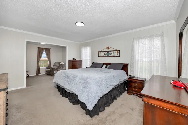 a spacious bedroom with a bed and a dresser