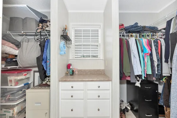 a view of walk in closet with clothes and shoes