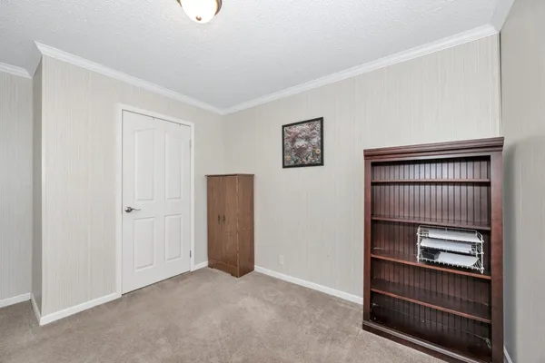 a view of kitchen and empty room with windows