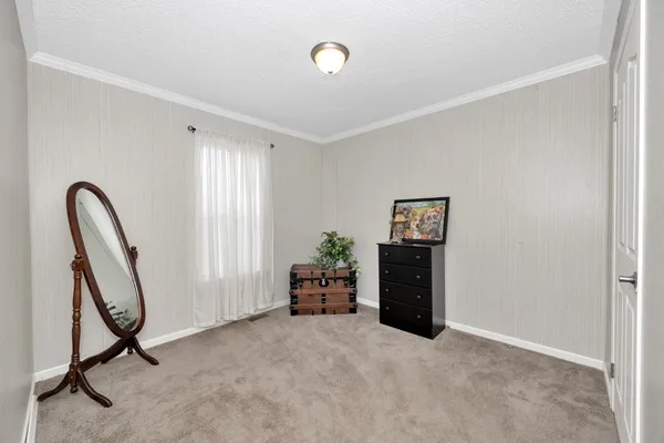 a view of a hallway with furniture and a window