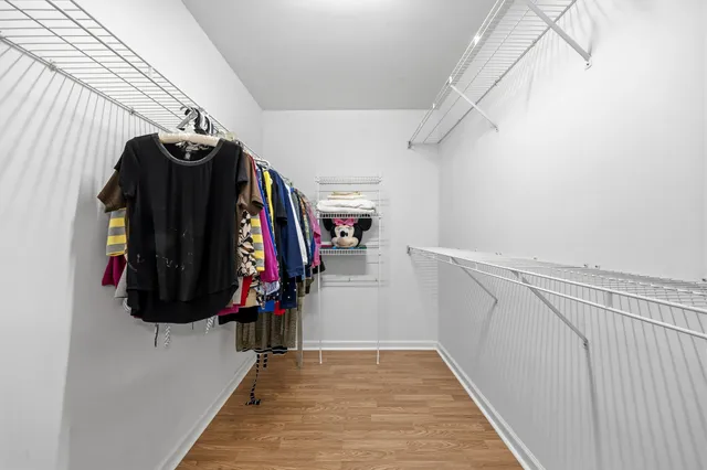 a view of walk in closet with clothes and shoes