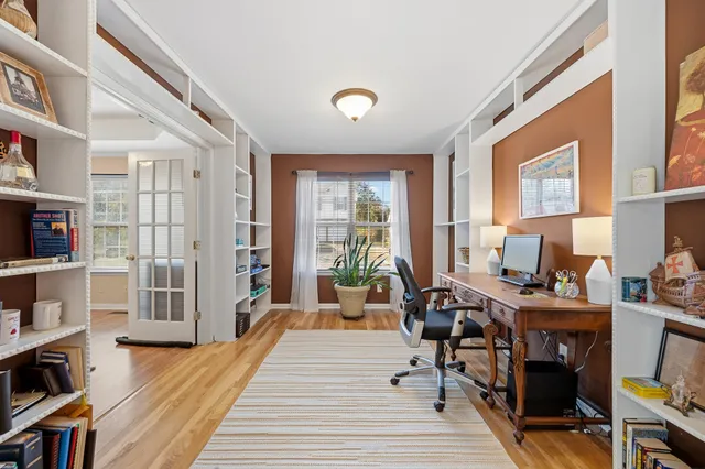 a living room with furniture a bookshelf and a window