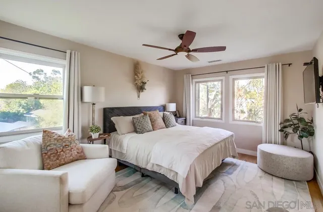 a bedroom with a large bed couch and a window