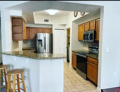 a kitchen with stainless steel appliances granite countertop a sink and a stove