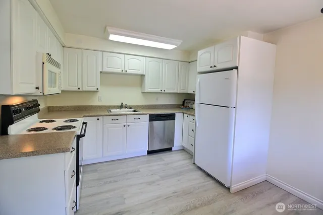 a kitchen with a stove a refrigerator and a sink