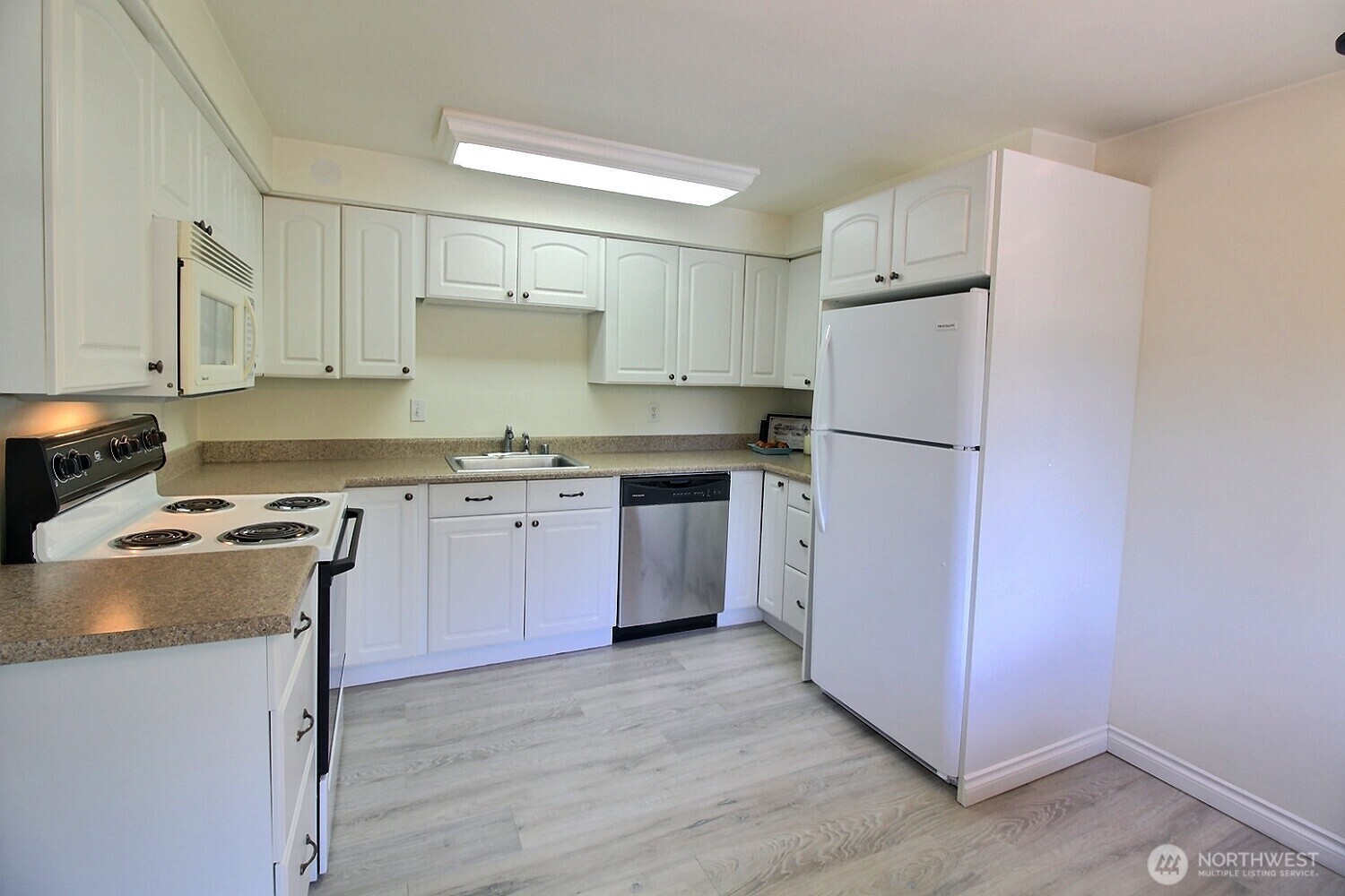 220 Southwest Clark Street, Unit B303 Issaquah, WA 98027 - Photo 4 of 19 a kitchen with a stove a refrigerator and a sink