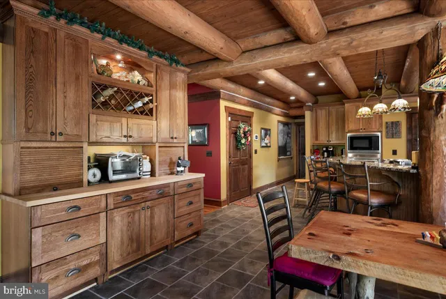 a kitchen with stainless steel appliances kitchen island granite countertop a table chairs in it and wooden floors