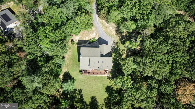an aerial view of a house with a yard and trees